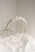 Load image into Gallery viewer, Floral headband on a white surface with a neutral background