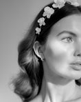 Load image into Gallery viewer, Black and white close-up of a woman wearing a floral headband with a neutral background