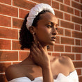 Load image into Gallery viewer, Woman wearing a white off-shoulder top and bridal headband against a brick wall.