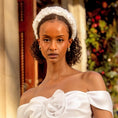 Load image into Gallery viewer, Woman wearing a white off-shoulder dress with a decorative bridal headband against a festive background.