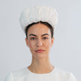 Load image into Gallery viewer, Woman wearing a white bridal headband against a light grey background