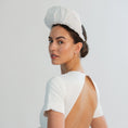 Load image into Gallery viewer, Woman wearing a white bridal headband against a light grey background