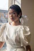 Load image into Gallery viewer, Woman wearing a white dress with puffed sleeves in an indoor setting.