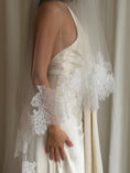 Load image into Gallery viewer, Bride wearing a white wedding dress with a lace veil against a white curtain background.