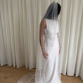 Charger l'image dans la visionneuse de la galerie, Person wearing a white wedding dress with a long plain veil against a plain background