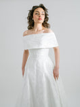 Load image into Gallery viewer, Woman wearing a white off-shoulder wedding dress against a plain background