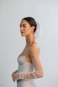 Load image into Gallery viewer, Woman wearing a white wedding dress with sheer sleeves against a plain background