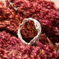 Load image into Gallery viewer, Silver ring on a textured pink surface