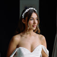 Load image into Gallery viewer, Woman in a white wedding dress holding a glass of champagne, wearing a floral headband.