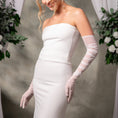 Load image into Gallery viewer, Woman wearing a white strapless dress and long gloves with a neutral background