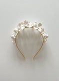 Load image into Gallery viewer, Floral headband with white flowers on a light gray background