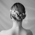 Load image into Gallery viewer, Black and white photo of a woman's head with a braided hairstyle and floral hair accessory.