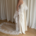 Load image into Gallery viewer, Bride wearing a white wedding dress with a lace veil against a white curtain background.