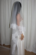 Load image into Gallery viewer, Bride wearing a white wedding dress with a lace veil against a white curtain background.