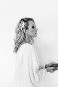 Load image into Gallery viewer, Black and white portrait of a woman with a flower in her hair, wearing a white dress.