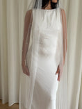 Load image into Gallery viewer, Person wearing a white wedding dress with a long pearl veil against a plain background