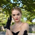 Load image into Gallery viewer, woman wearing Cornelia James black short satin bridal gloves with a side bow detail.