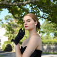 Load image into Gallery viewer, woman wearing Cornelia James short black satin bridal gloves with a side bow detail