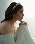 Load image into Gallery viewer, Woman wearing a floral headband and white off-shoulder top against a bright background