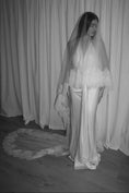 Load image into Gallery viewer, Bride wearing a white wedding dress with a lace veil against a white curtain background.