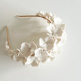 Load image into Gallery viewer, Floral headband with white flowers on a light gray background