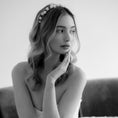 Load image into Gallery viewer, Black and white portrait of a woman with a floral headband, sitting on a couch.