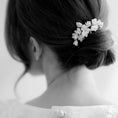 Load image into Gallery viewer, Black and white photo of a person with a floral hair accessory.