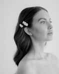 Load image into Gallery viewer, Woman with floral hair clips on a plain background