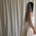 Bild in Galerie-Betrachter laden, Bride wearing a white wedding dress with a plain veil against a white curtain background.