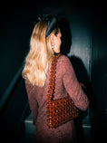 Load image into Gallery viewer, Woman holding a brown beaded bridal handbag against a dark background