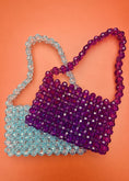 Load image into Gallery viewer, Two beaded bridal handbags, one purple and one blue, on an orange background