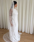 Charger l'image dans la visionneuse de la galerie, Woman wearing a white lace veil and wedding dress against a white curtain background