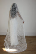 Load image into Gallery viewer, Woman wearing a white lace veil and wedding dress against a white background
