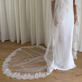 Bild in Galerie-Betrachter laden, White wedding dress with a long lace veil in front of a white curtain.
