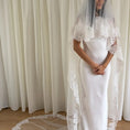 Bild in Galerie-Betrachter laden, White wedding dress with a long lace veil in front of a white curtain.