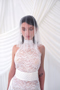 Load image into Gallery viewer, A bride shown from the front wearing a sheer white tulle bridal veil with delicate bead and sequin embellishments, paired with a white wedding dress against a soft white draped backdrop.