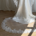 Charger l'image dans la visionneuse de la galerie, Bride wearing a white wedding dress with a lace veil against a white curtain background.