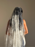 Load image into Gallery viewer, A woman shown from the back wearing a long white lace bridal veil over dark hair, photographed against a plain warm gray studio background.