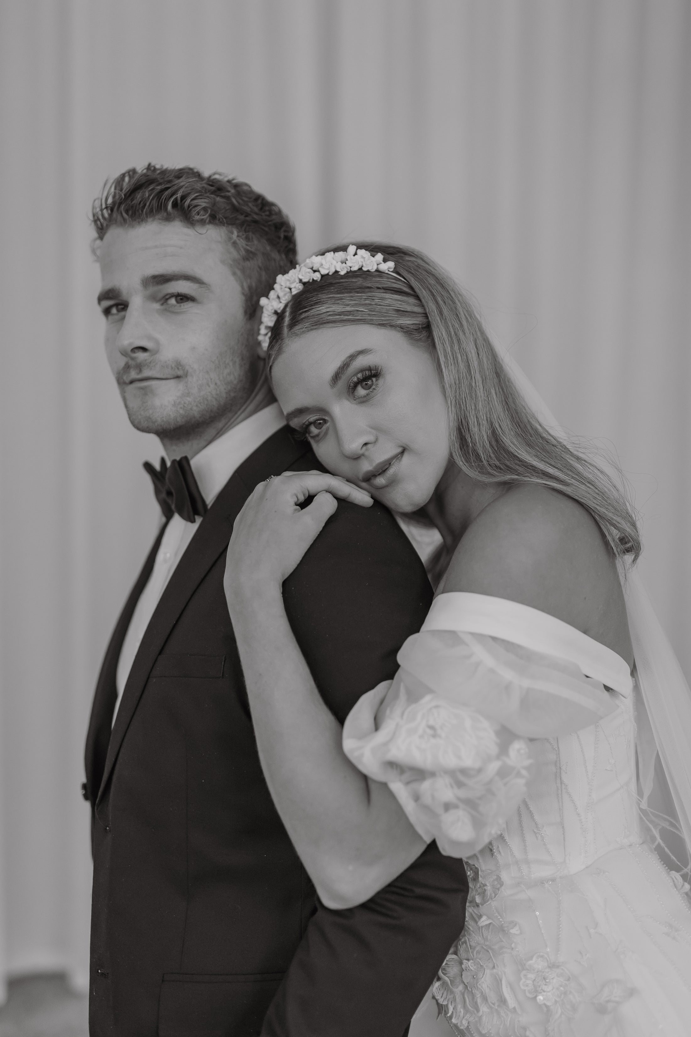 Black and white photo of a couple in formal attire, likely at a wedding.