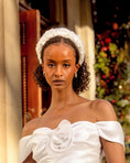 Load image into Gallery viewer, Woman wearing a white off-shoulder dress with a decorative bridal headband against a festive background.
