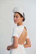 Load image into Gallery viewer, Woman wearing a white bridal headband against a light grey background

