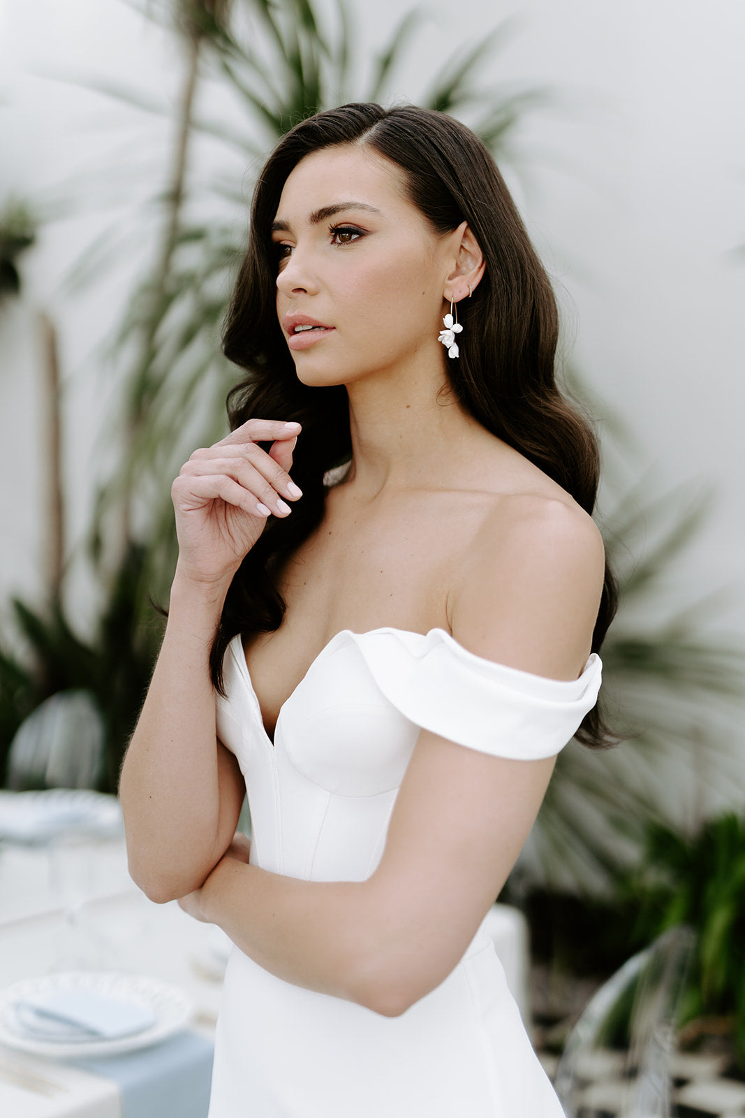 Woman in a white off-shoulder dress with a blurred outdoor background