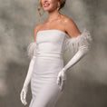 Load image into Gallery viewer, Woman wearing a white strapless gown with feathered shoulders and long gloves against a gray background
