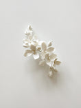 Load image into Gallery viewer, White floral hair accessory on a light gray background
