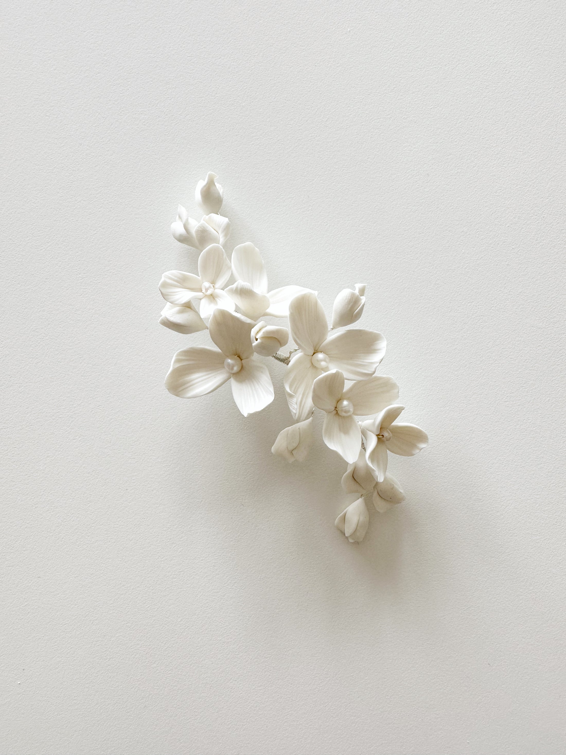White floral hair accessory on a light gray background