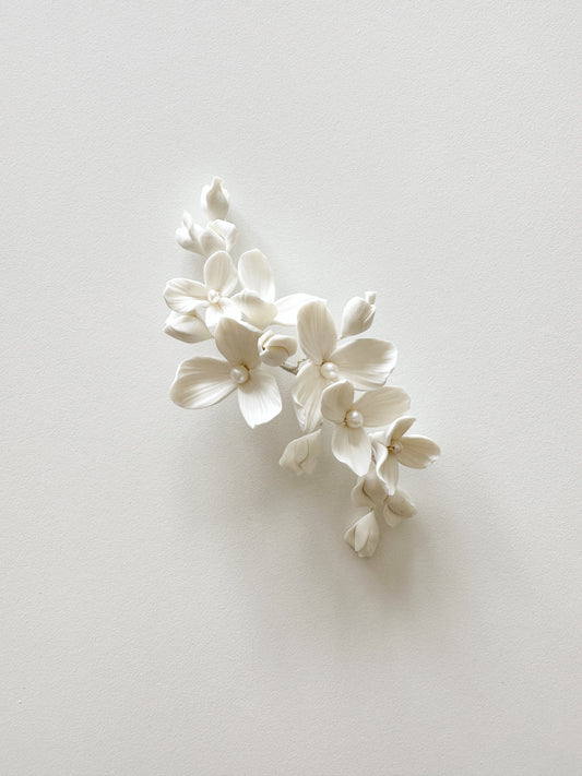 White floral hair accessory on a light gray background