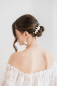 Load image into Gallery viewer, Woman wearing a white off-shoulder dress against a plain background wearing silk flower bridal earrings
