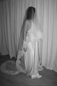 Load image into Gallery viewer, Bride wearing a white wedding dress with a lace veil against a white curtain background.
