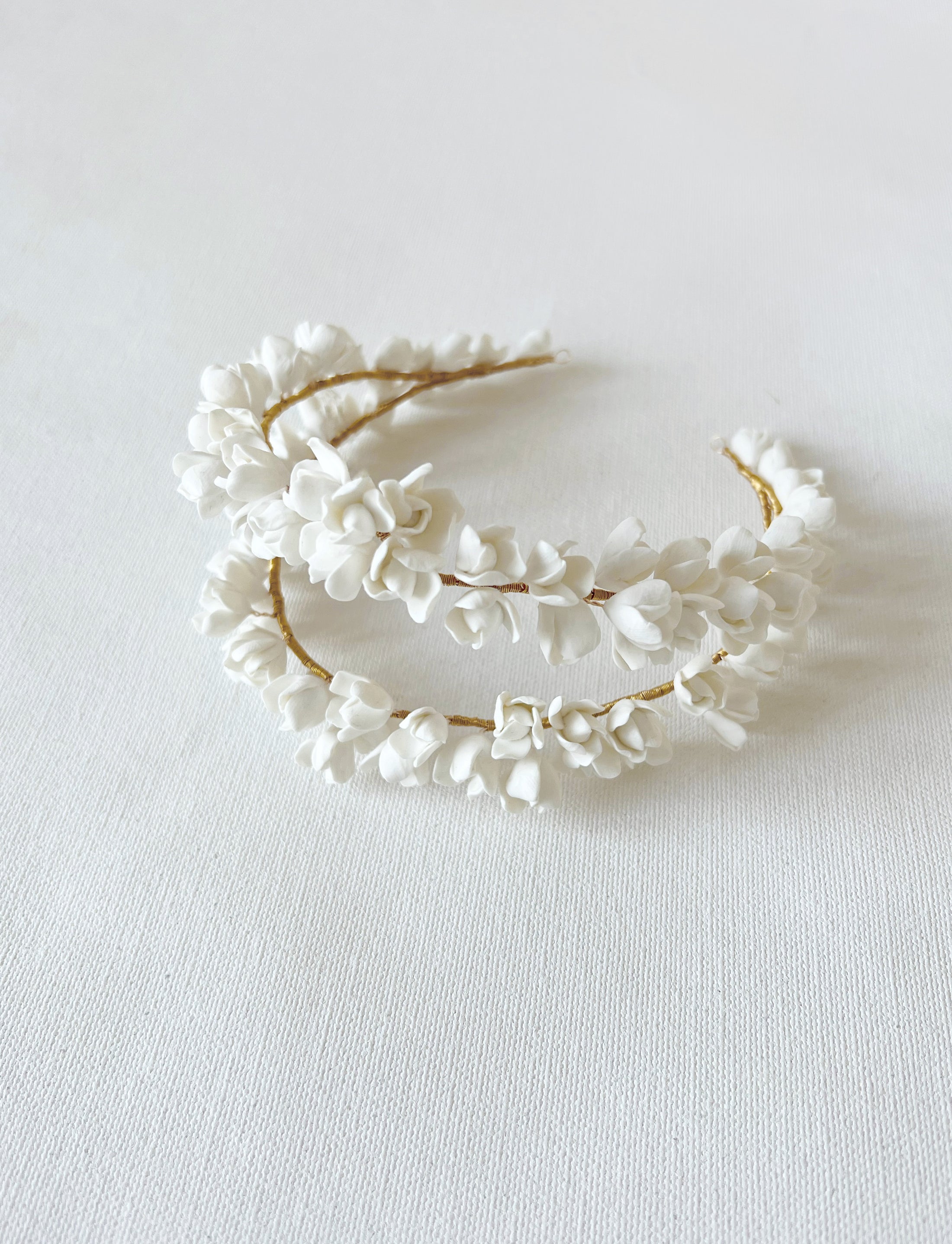 White floral headband on a light gray background