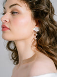 Load image into Gallery viewer, Close-up of a woman wearing floral earrings with a neutral background
